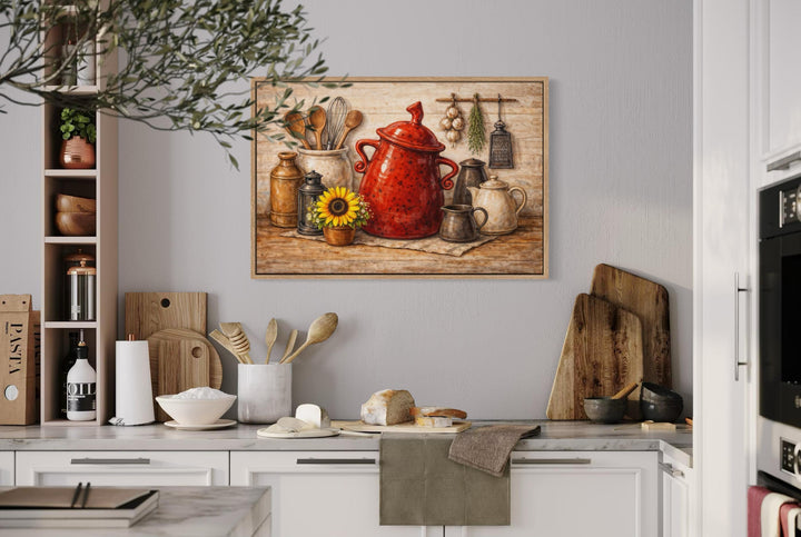 Rustic farmhouse kitchen wall art featuring a red ceramic pot and utensils in a wooden frame.