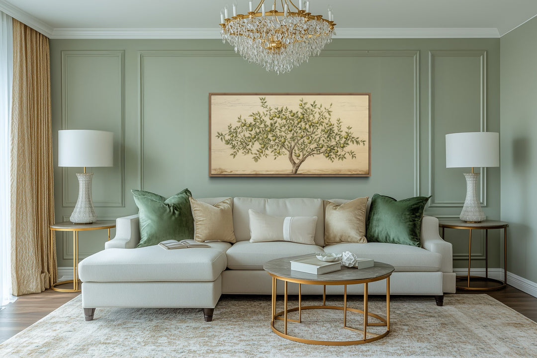 Rustic farmhouse apple tree canvas wall art in a gold frame above a light beige sectional sofa.