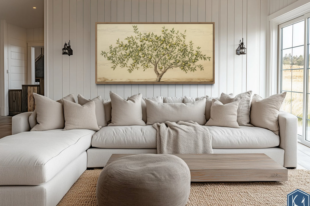 Rustic farmhouse apple tree canvas wall art above a neutral sectional sofa in a cozy living room.