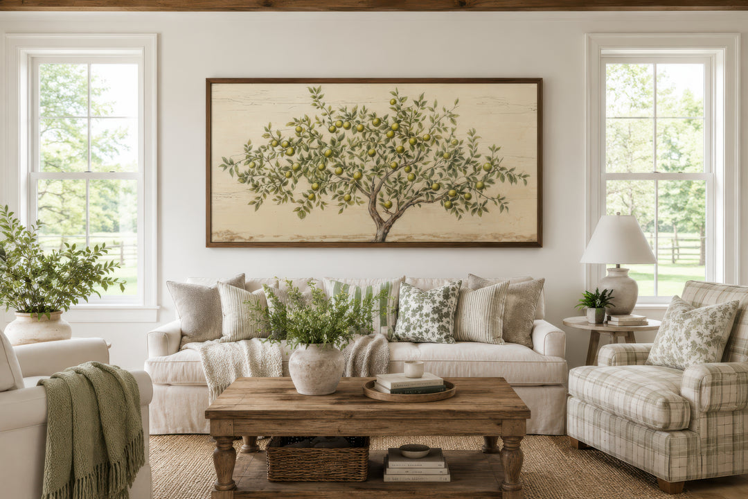 Rustic framed canvas wall art of an apple tree with green leaves and fruit in a farmhouse living room