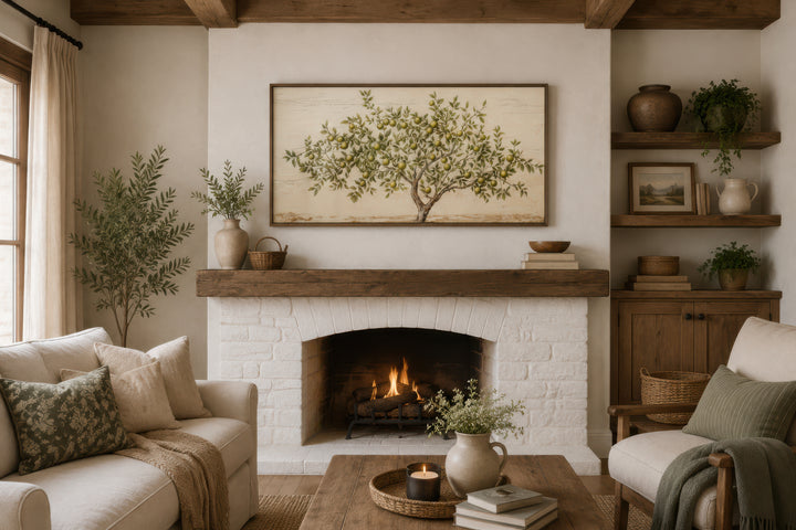 Framed rustic apple tree canvas wall art hanging above a white brick fireplace in a cozy living room.