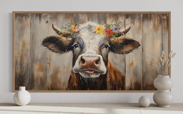 Rustic farmhouse wall art featuring a curious cow with a floral crown on a wood-framed canvas.