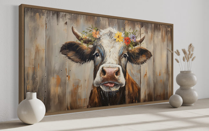 Rustic farmhouse wall art featuring a curious cow with a floral crown on a wood-framed canvas.