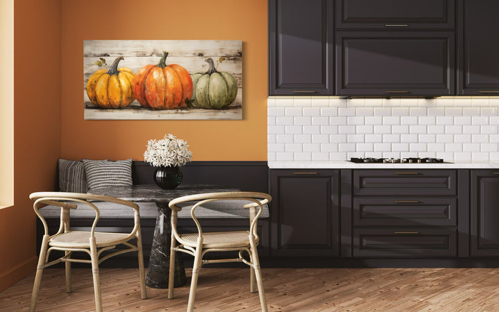 Rustic farmhouse wall art featuring three pumpkins on a wood-style background in a modern kitchen.