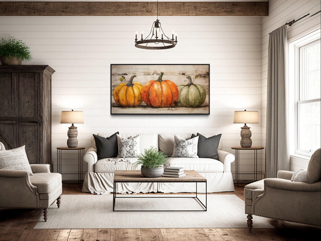 Rustic farmhouse wall art featuring three pumpkins on a framed canvas in a cozy living room.