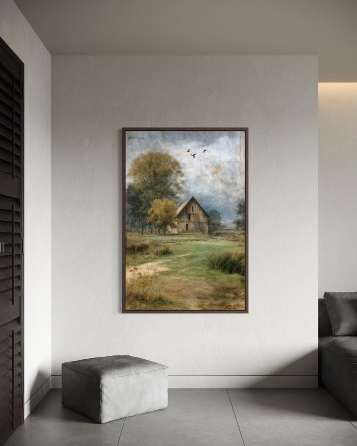 Vertical rustic barn canvas print in a dark wood frame on a neutral wall.