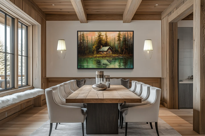 Rustic lake and cabin framed canvas wall art hanging in a modern wooden dining room.