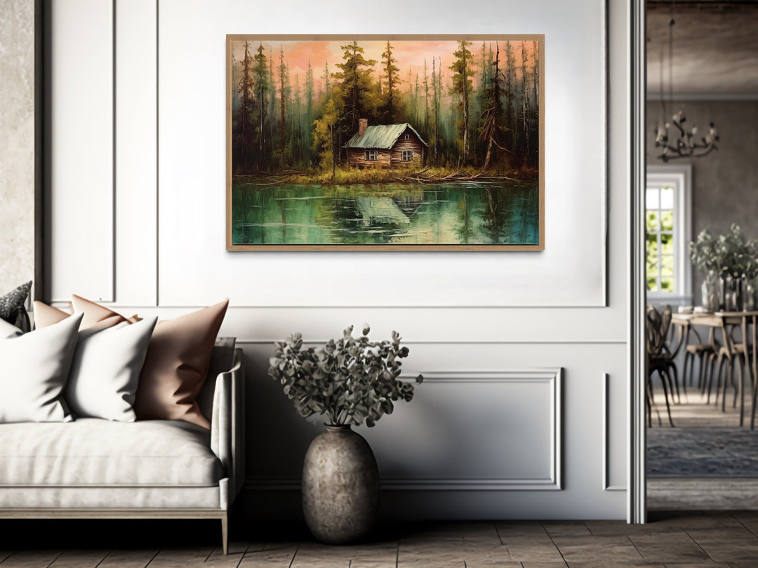 Rustic lake and cabin framed canvas wall art hanging above a sofa in a modern living room.
