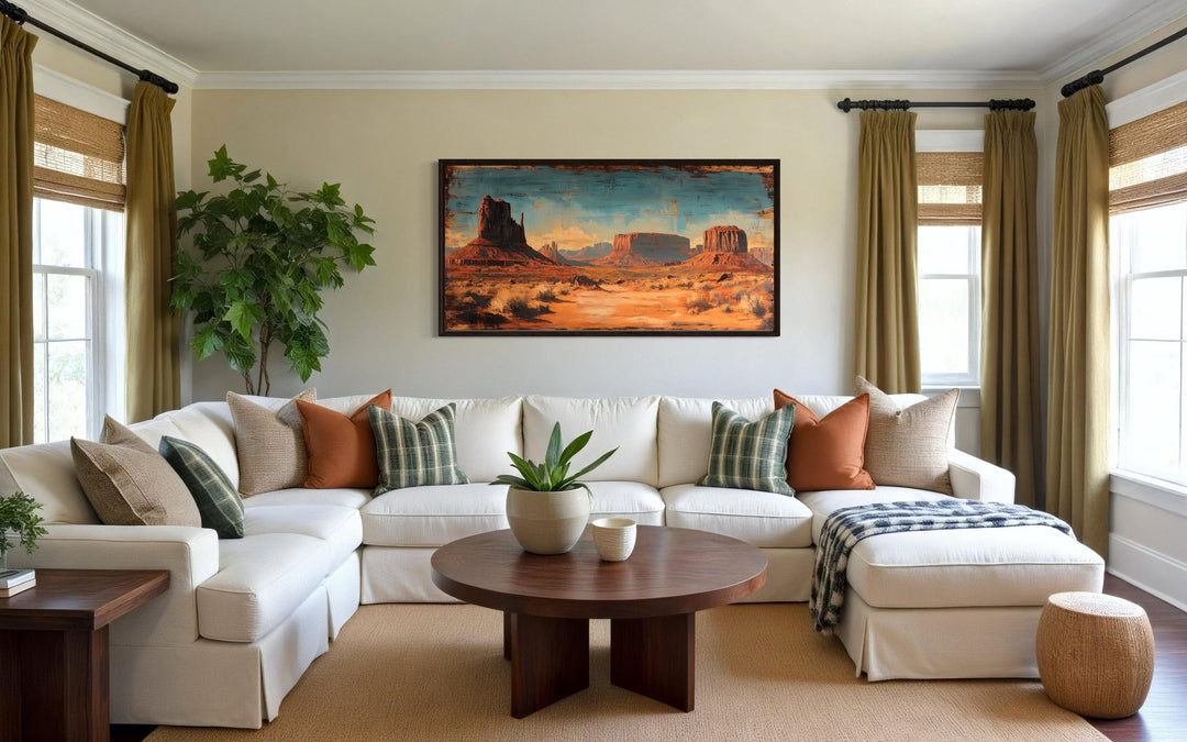 Rustic Monument Valley framed canvas wall art hanging above a white sectional sofa in a living room.