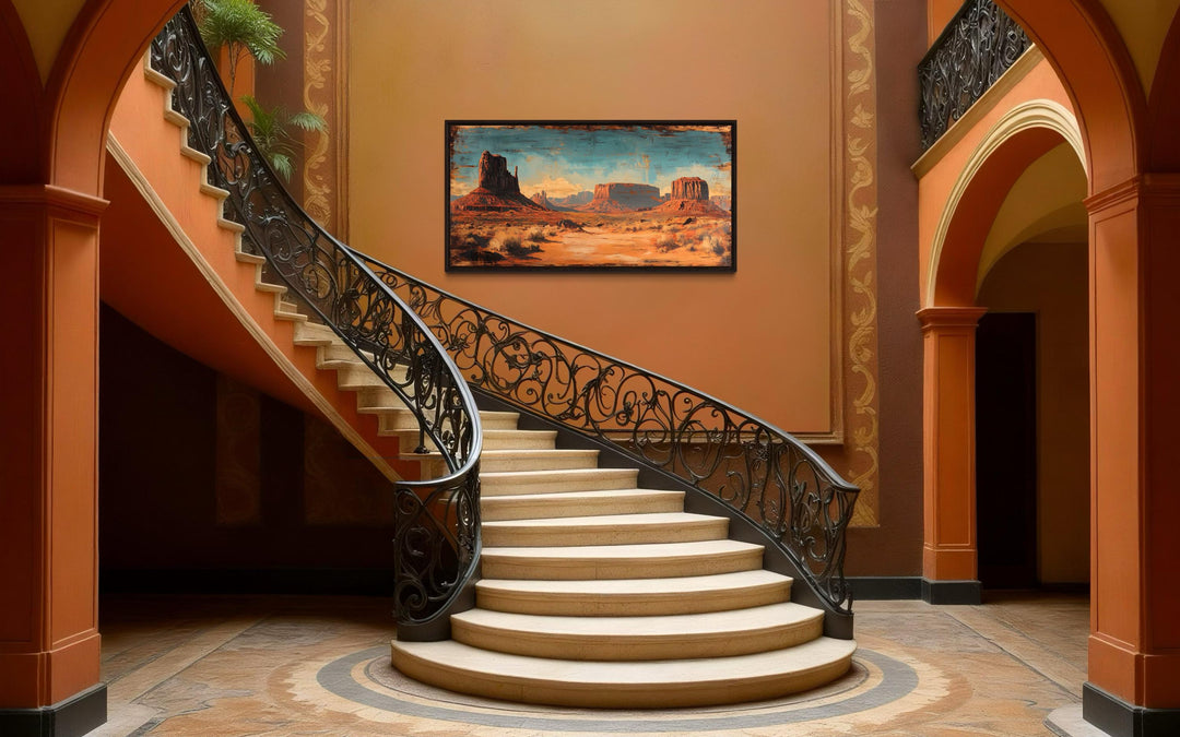 Rustic Monument Valley framed canvas wall art hanging on a wall above a grand spiral staircase.