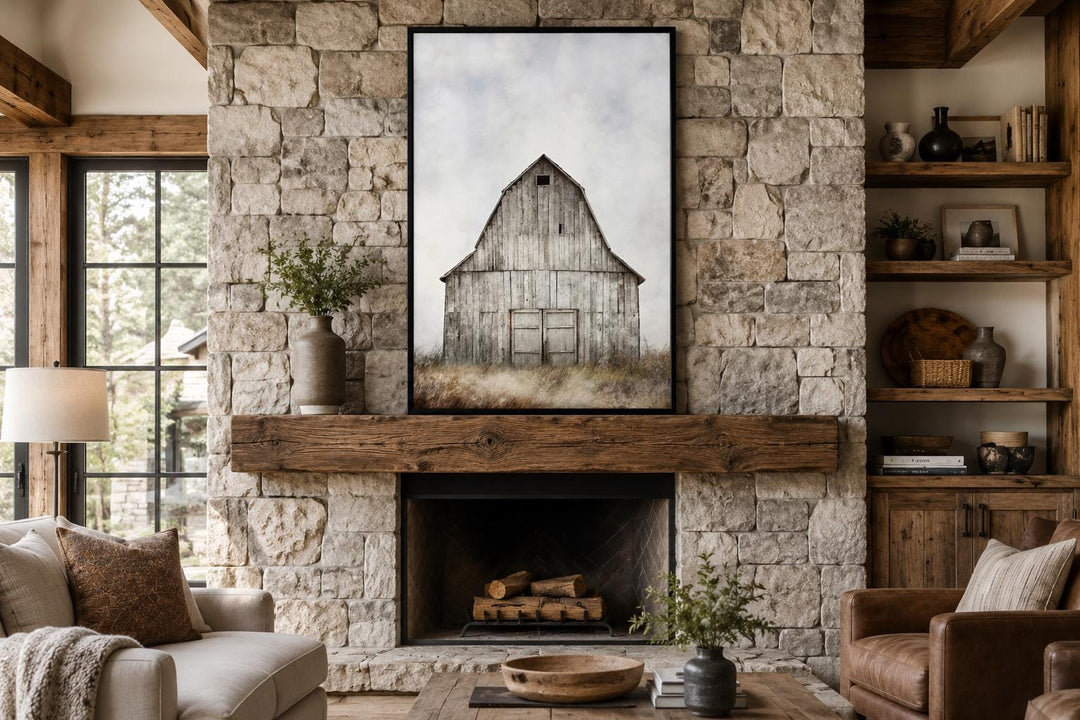 Vertical canvas print of a weathered rustic barn above a stone fireplace in a farmhouse living room.