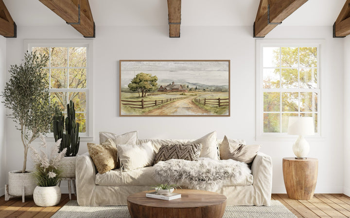 Rustic old barn landscape painting on wood canvas wall decor above a white sofa in a living room.