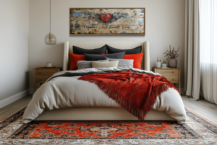 Rustic framed wall art above a bed featuring a winged heart and "Together, our hearts sing" text.