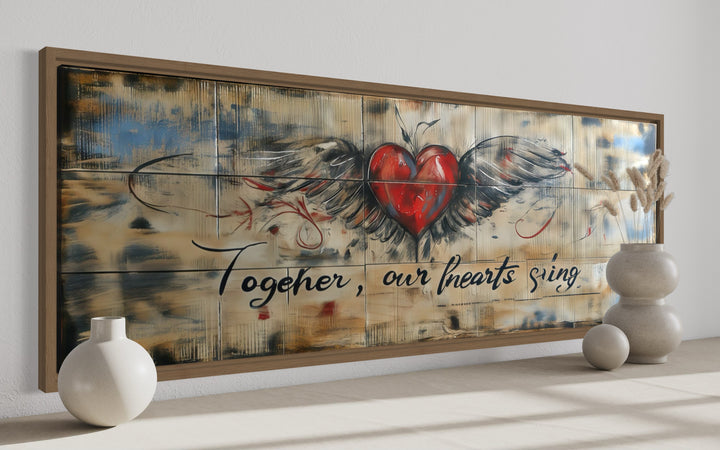 Rustic framed wall art with a winged red heart and the text Together, our hearts sing.