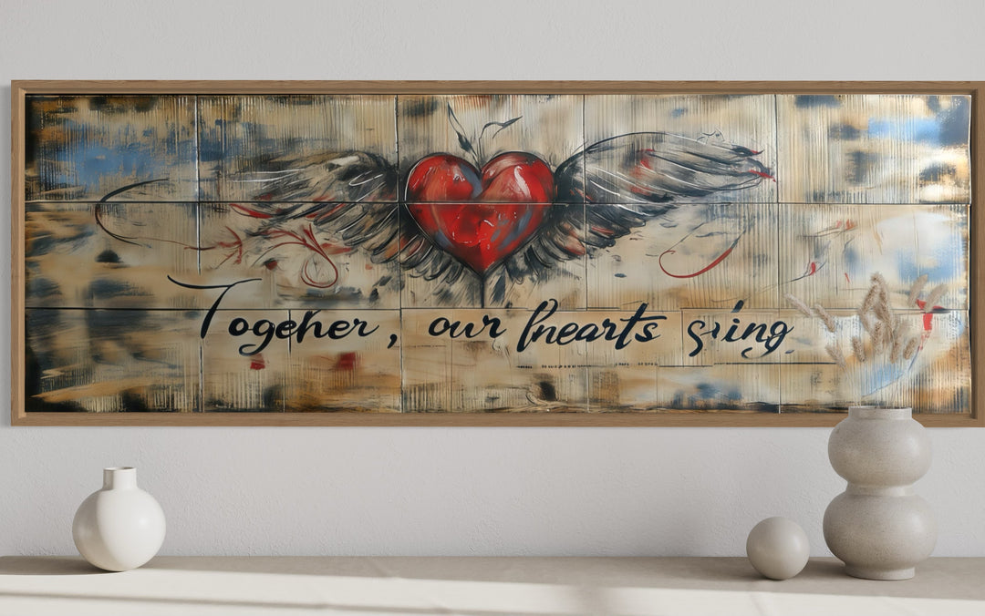 Rustic framed wall art with a winged heart and the text Together Our Hearts Sing over a bed.