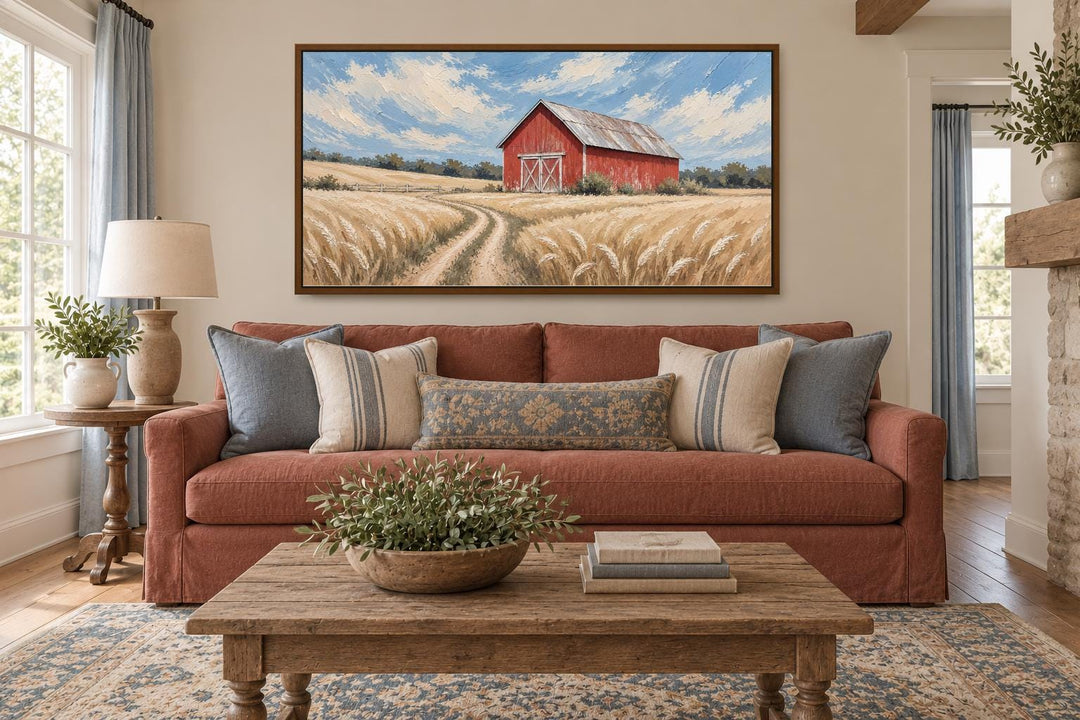 Rustic red barn in a golden wheat field landscape canvas wall art hanging above a sofa.
