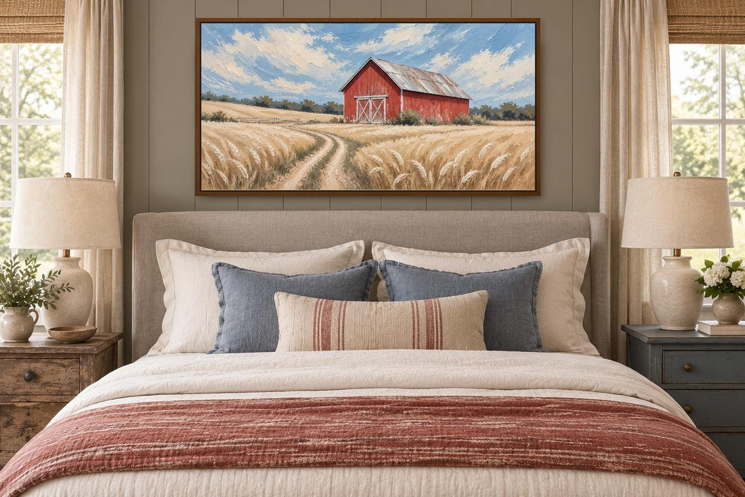 Rustic red barn in a golden wheat field landscape canvas wall art hanging above a bed.