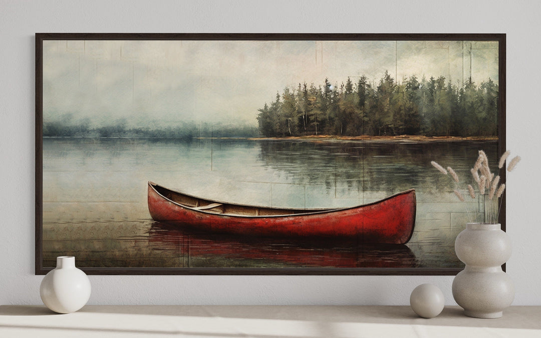 Framed canvas wall art of a rustic red canoe on a calm lake with a forest background.