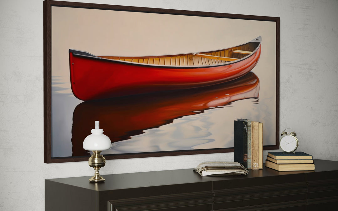 Framed canvas print of a red canoe on calm water, styled above a dark wood dresser.