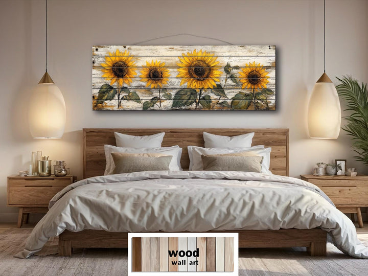 Rustic sunflower wall art on a long whitewashed wood panel hanging above a bed in a farmhouse bedroom.