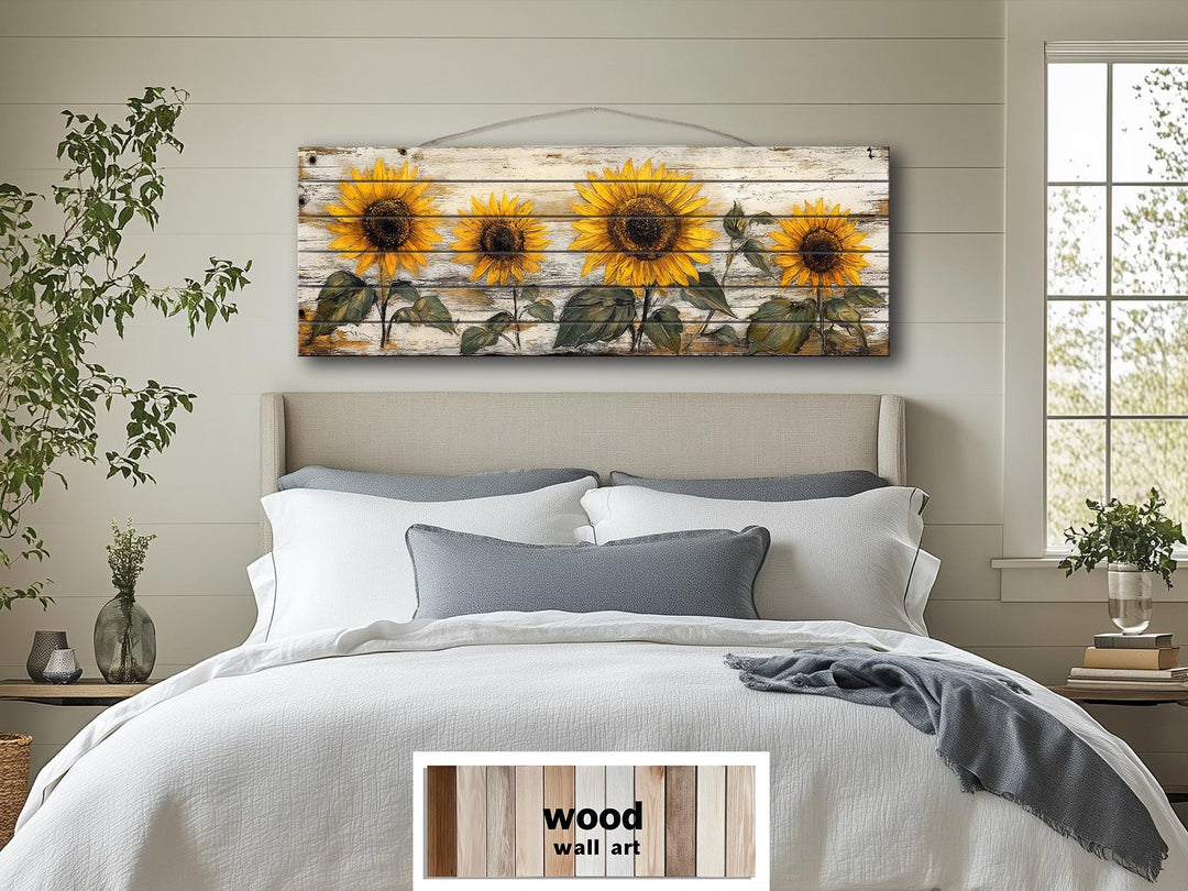 Rustic sunflower wall art on a long whitewashed wood panel hanging above a bed.