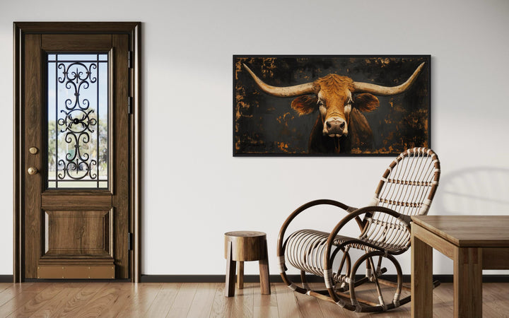 Extra large rustic Texas longhorn cow wall art in a black frame above a rocking chair.