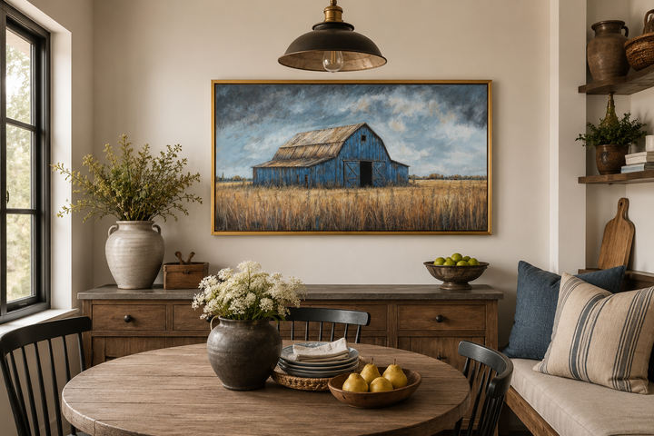 Rustic blue barn framed canvas wall art hanging above a wooden buffet in a farmhouse dining room.