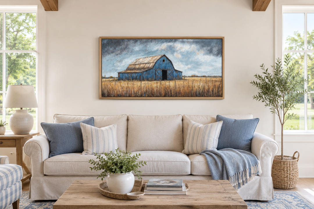 Rustic blue barn framed canvas wall art hanging above a beige sofa in a farmhouse living room.
