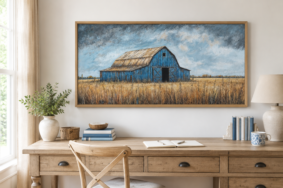 Rustic blue barn framed canvas wall art hanging above a wooden desk in a farmhouse-style room.