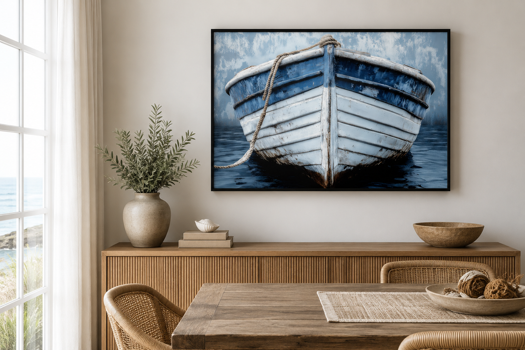 Rustic blue and white distressed boat canvas print in a black frame above a wooden sideboard.