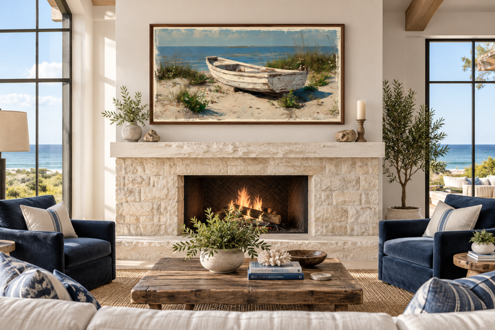 Old white boat on the beach coastal framed canvas wall art hanging above a stone fireplace.