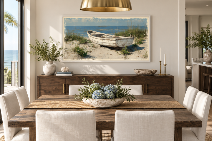 Old white boat on the beach coastal framed canvas wall art hanging in a neutral dining room.