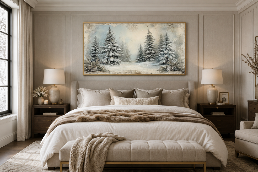 Framed canvas wall art of a snowy fir tree forest hanging above a bed in a neutral bedroom.