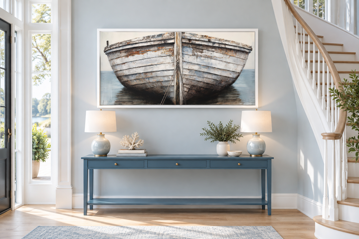 Rustic old boat close-up framed canvas wall art above a blue console table in a coastal entryway.