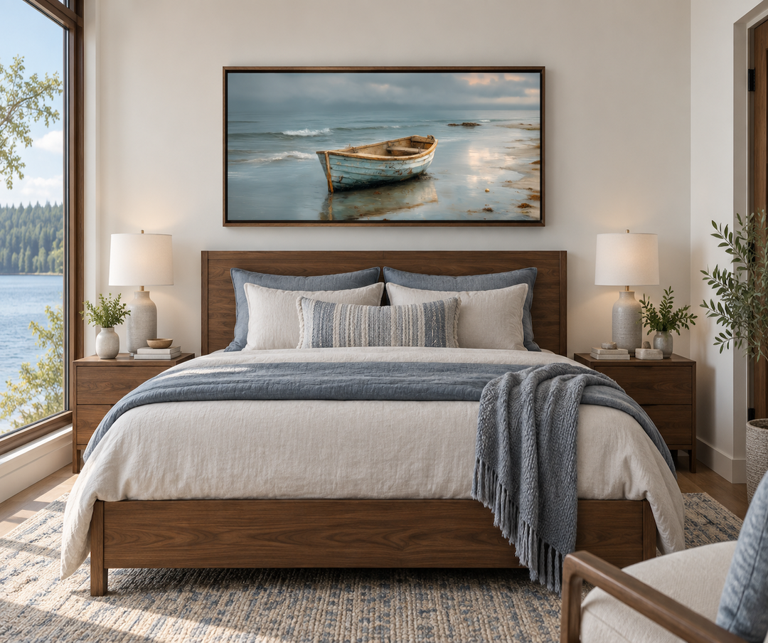 Rustic rowboat on beach coastal framed canvas wall art hanging above a bed in a modern bedroom.