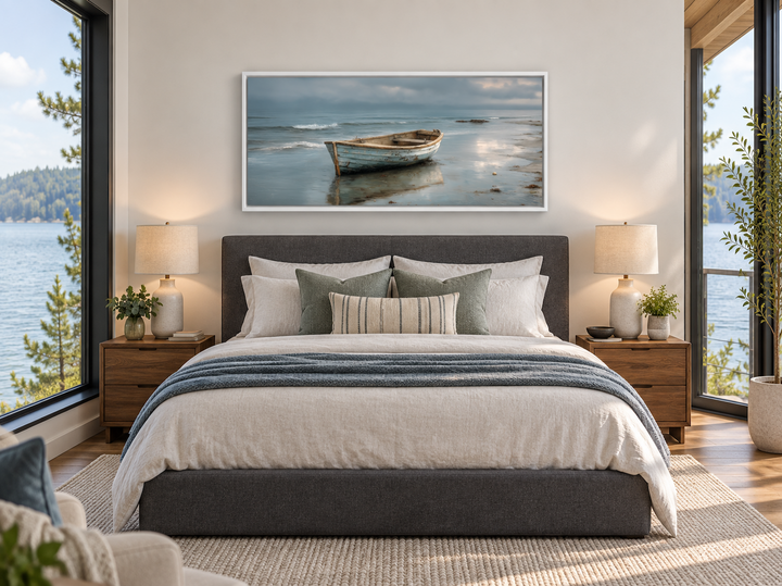Rustic rowboat on beach coastal framed canvas wall art hanging above a bed in a modern bedroom.