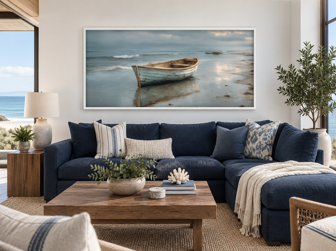 Rustic rowboat on beach coastal framed canvas wall art hanging above a navy blue sectional sofa.