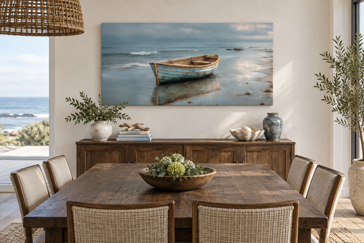 Rustic rowboat on beach coastal framed canvas wall art hanging above a wooden sideboard.