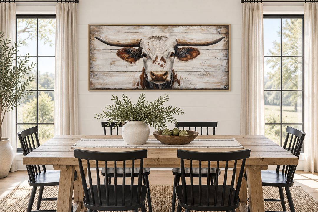 Rustic Texas Longhorn framed canvas wall art on a white wood background above a dining table.