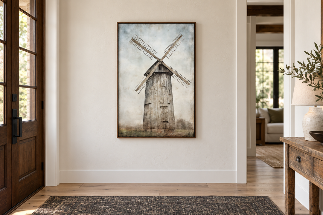 Rustic old windmill painting in a brown frame hanging on a neutral wall in a farmhouse entryway.