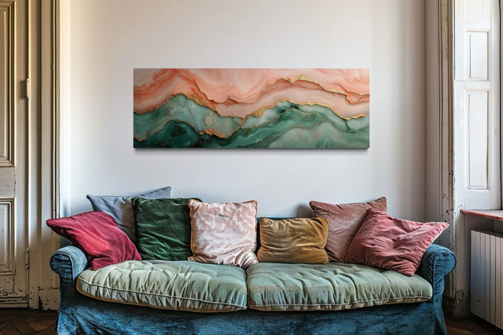 Sage green and blush pink abstract marble canvas wall art above a velvet sofa with colorful pillows.