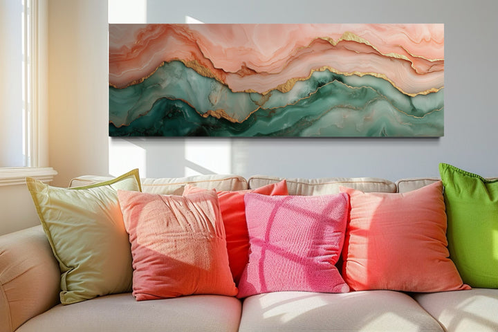 Sage green and blush pink abstract marble canvas wall art hanging above a sofa with colorful pillows.