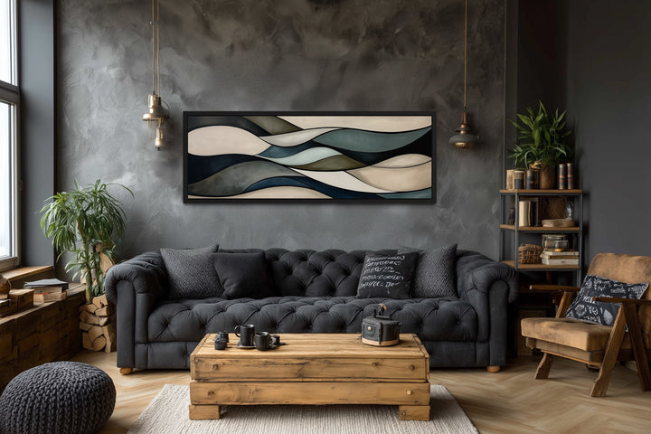 Sage green and brown modern abstract horizontal framed wall art hanging above a dark grey sofa.