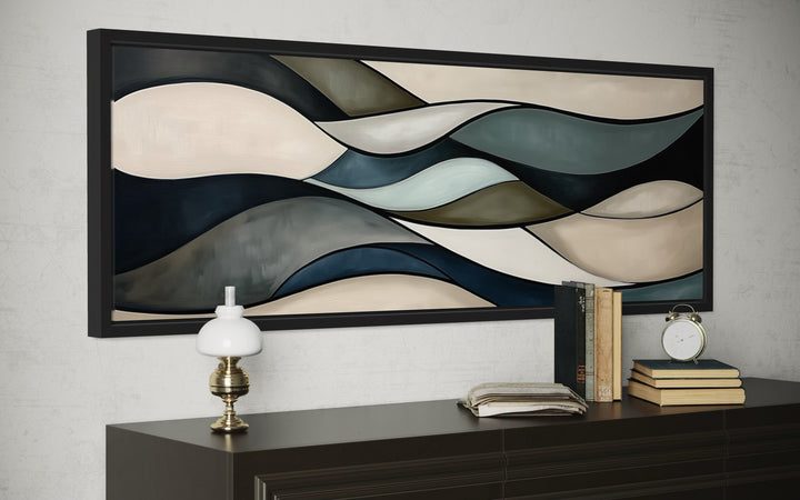 Horizontal abstract wall art with sage green, brown, and blue wavy shapes in a black frame.