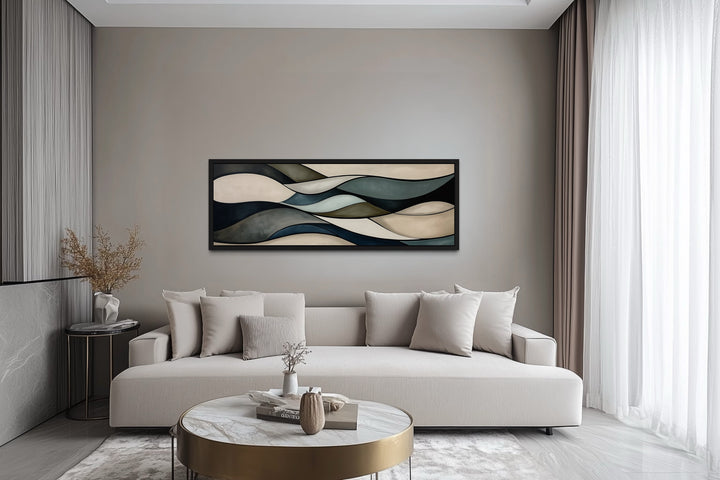 Sage green and brown modern abstract horizontal framed wall art hanging above a beige sofa.