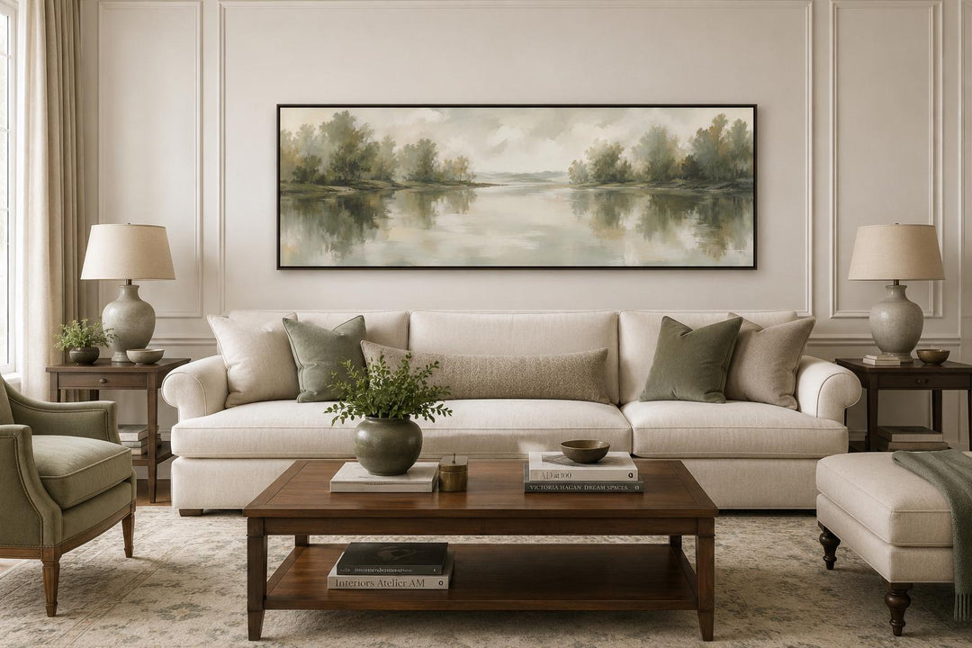 Sage green lake reflection landscape canvas print hanging above a sofa in a neutral living room.