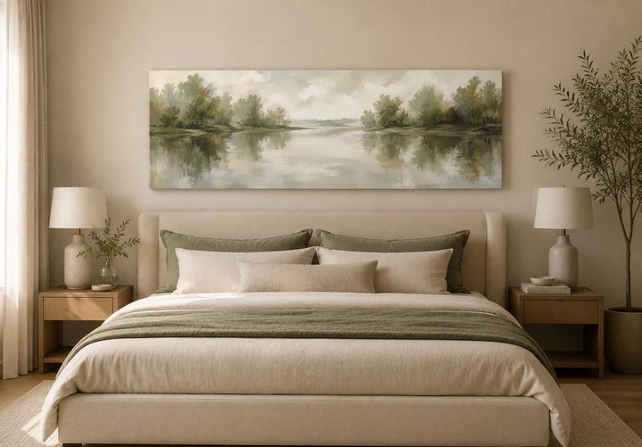 Sage green lake reflection landscape canvas print hanging above a bed in a neutral bedroom.