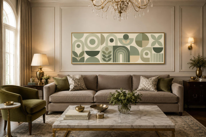 Long narrow sage green geometric canvas print with Bauhaus shapes above a sofa in a living room.