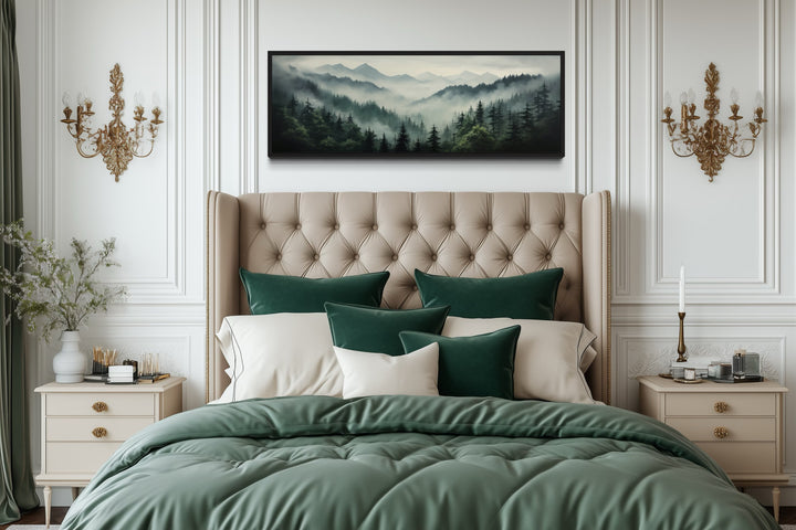 Sage green moody foggy pine forest mountains landscape wall art hanging above a tufted bed.