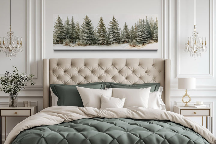 Sage green pine trees wall art on a long horizontal canvas above a tufted headboard.